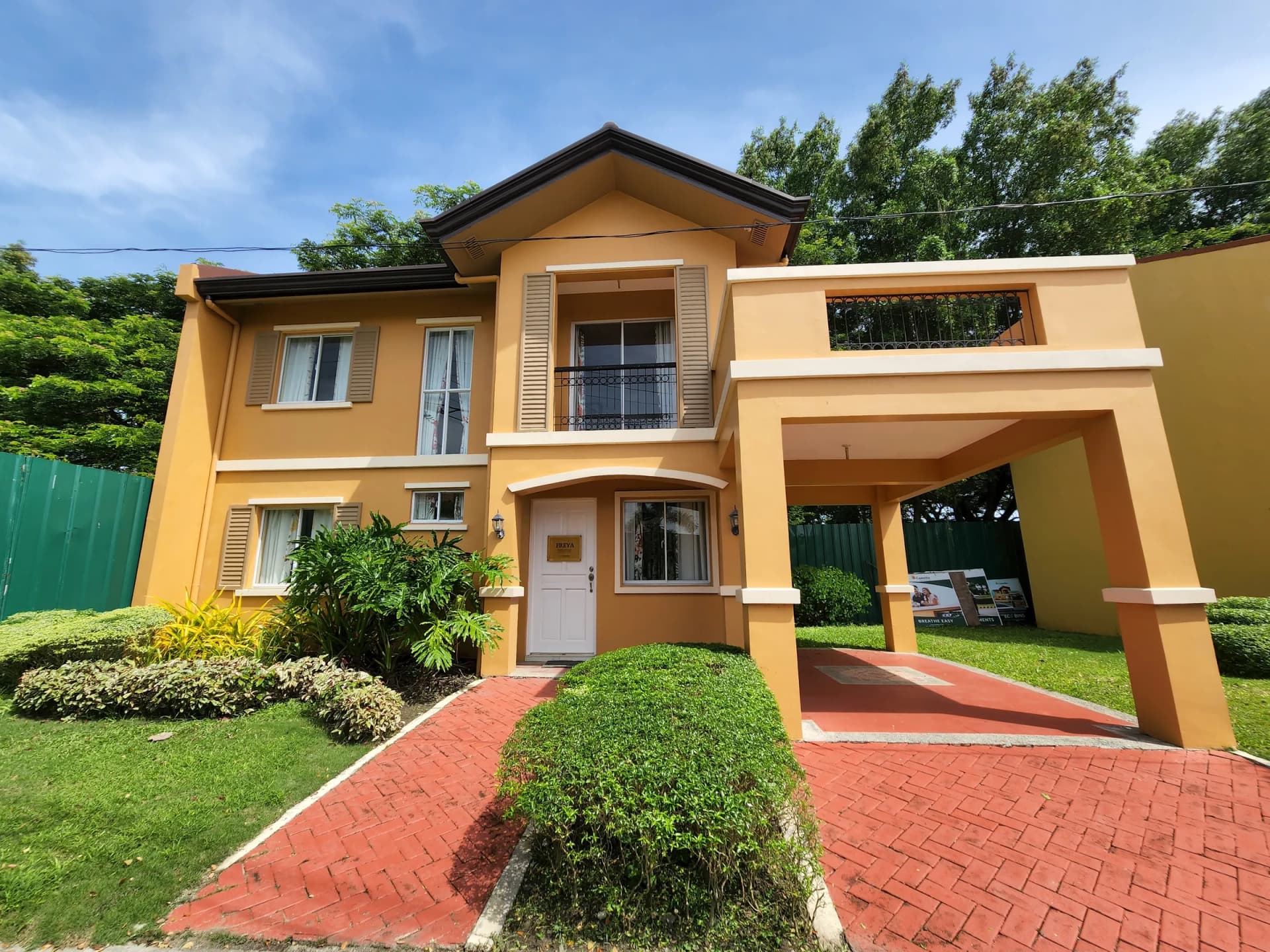 Two-storey Camella model house with a front garden and brick driveway